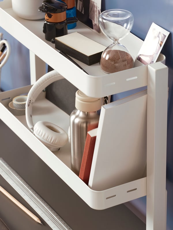VATTENKAR desktop shelf for organising stationery in black screwed on the table. It has neatly organised items on top as well as 