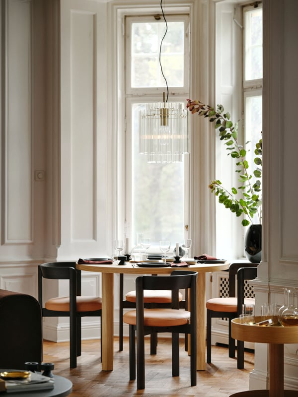 A black STOCKHOLM 2025 vase in the dining room