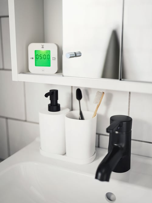 Bathroom focus of a black and white 3 piece bathroom set consisting of a soap dispenser, toothbrush holder and a tray.