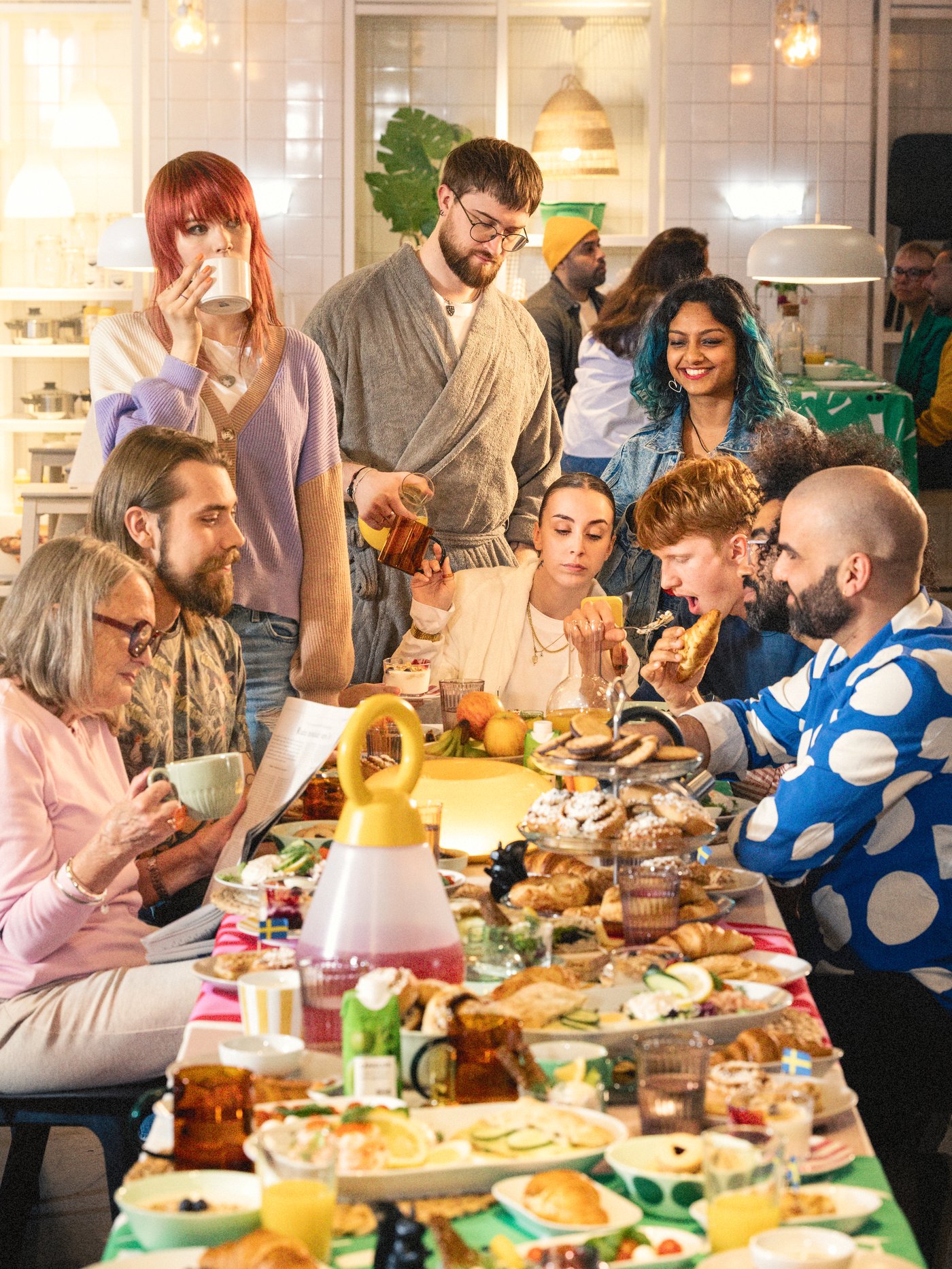 En gruppe smilende mennesker nyder en morgenmadsbuffet i et IKEA varehus.