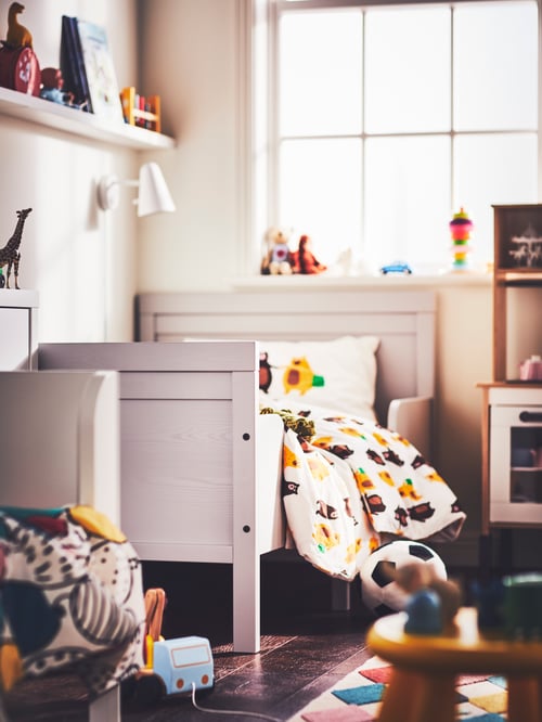 Modernes Kinderzimmer mit einem SUNDVIK ausziehbaren Bettgestell mit Federholzrahmen, einer FUBBLA LED-Wandleuchte und der BRUMMIG Bettwäsche.