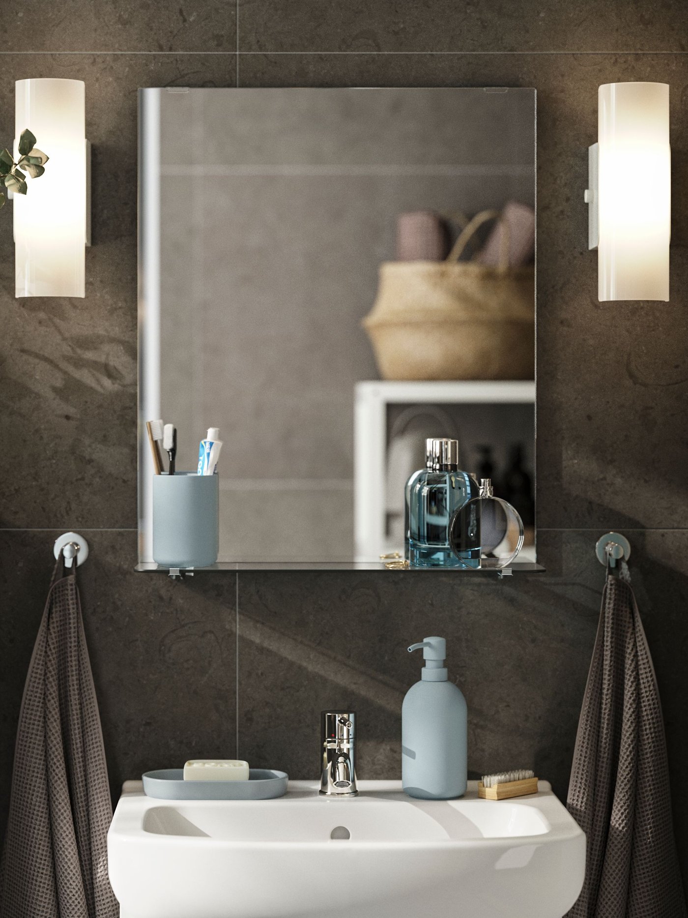 A rectangular NYSJÖN mirror with a glass shelf holds toothbrushes and perfume bottles above a white wash-basin and cabinet.
