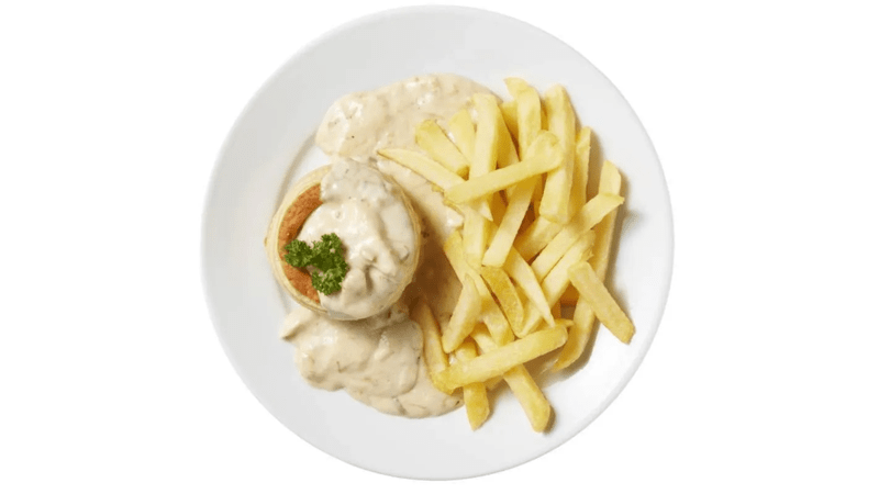Bord met vol‑au‑vent in romige saus naast een portie gouden frieten op een witte achtergrond.