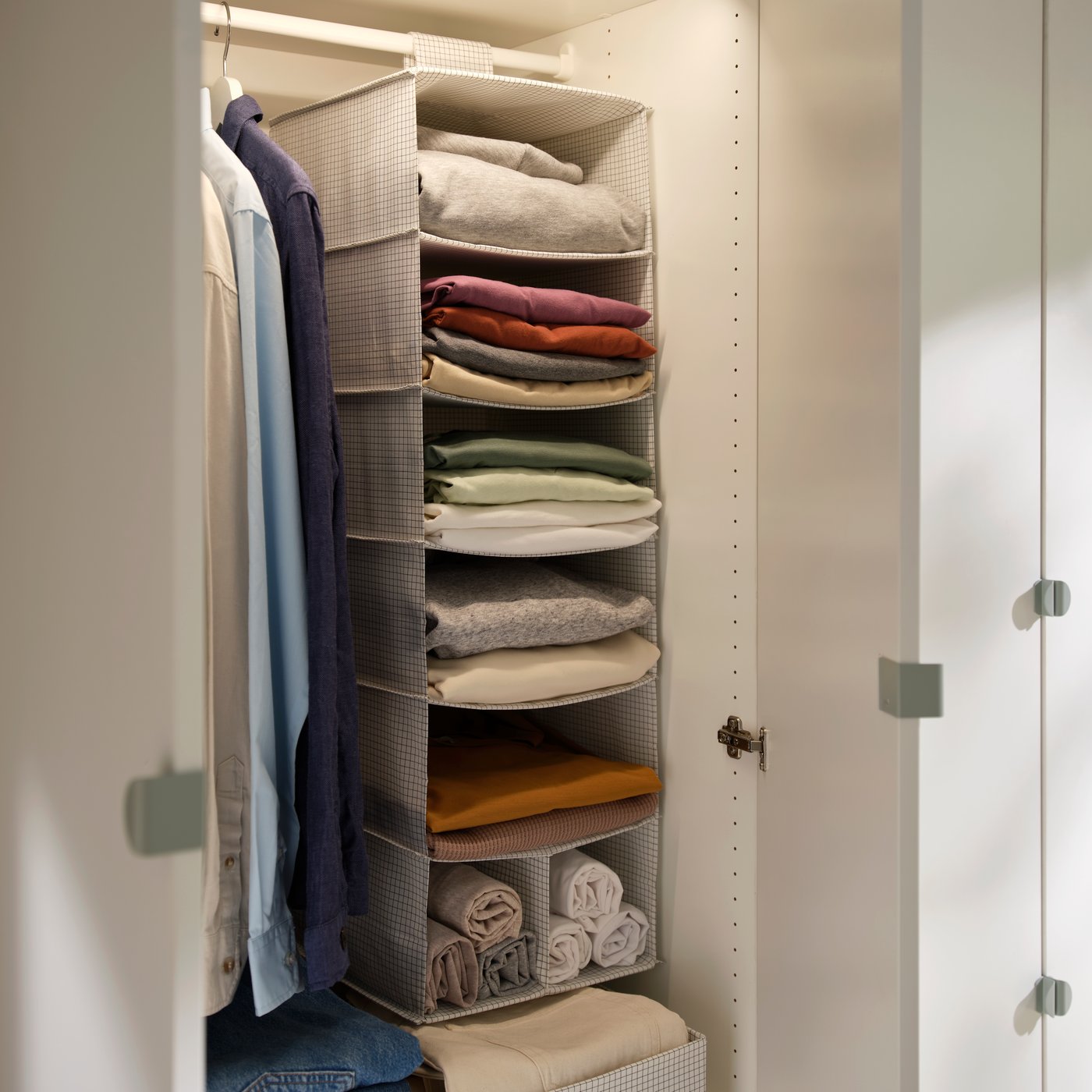 STUK hängande förvaring i vitt med flera hyllor som håller vikta kläder och handdukar inne i en garderob