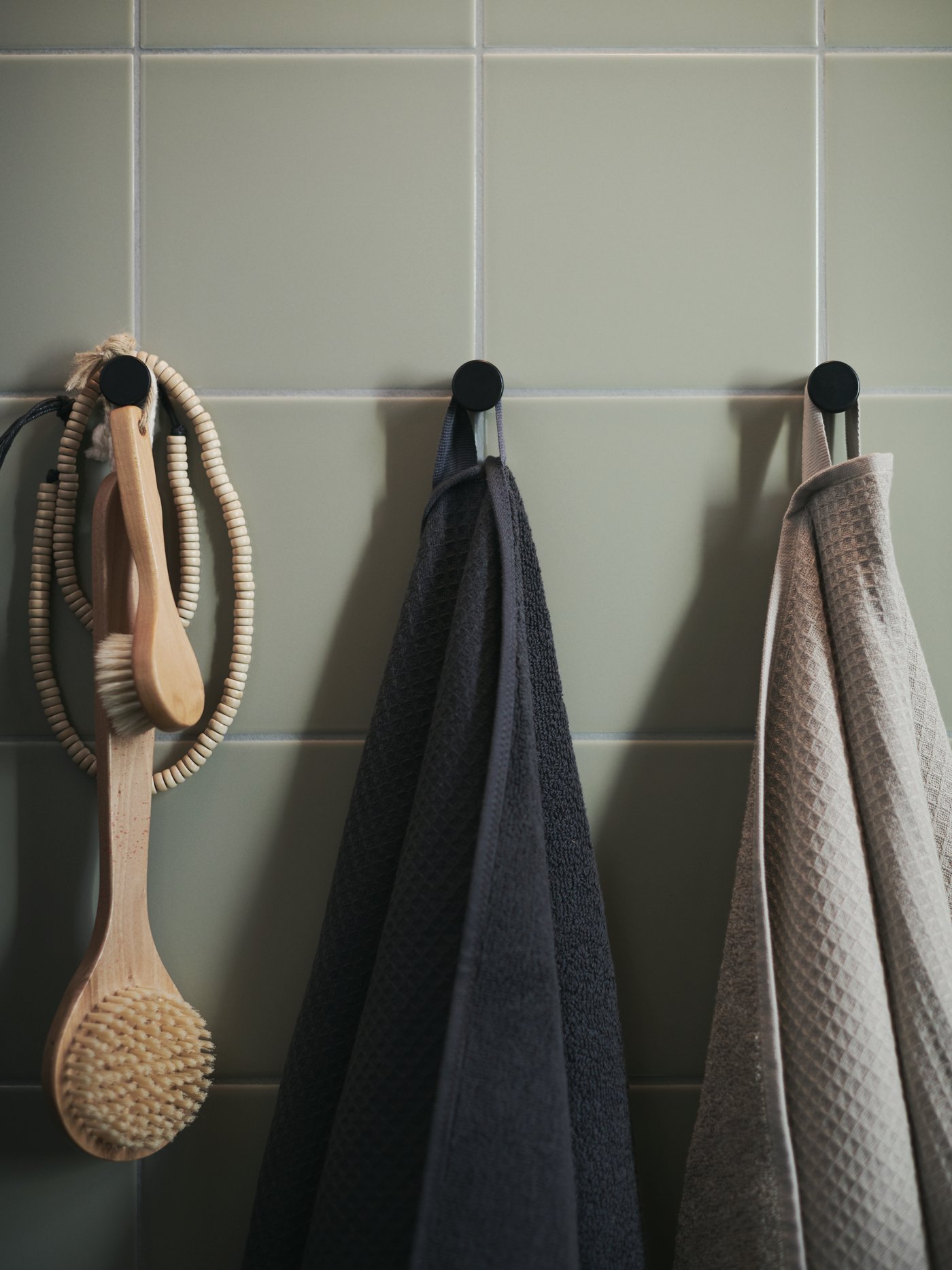 مناشف SALVIKEN بلون أنثراسيت وبيج غامق تتدلى من العلّاقات.