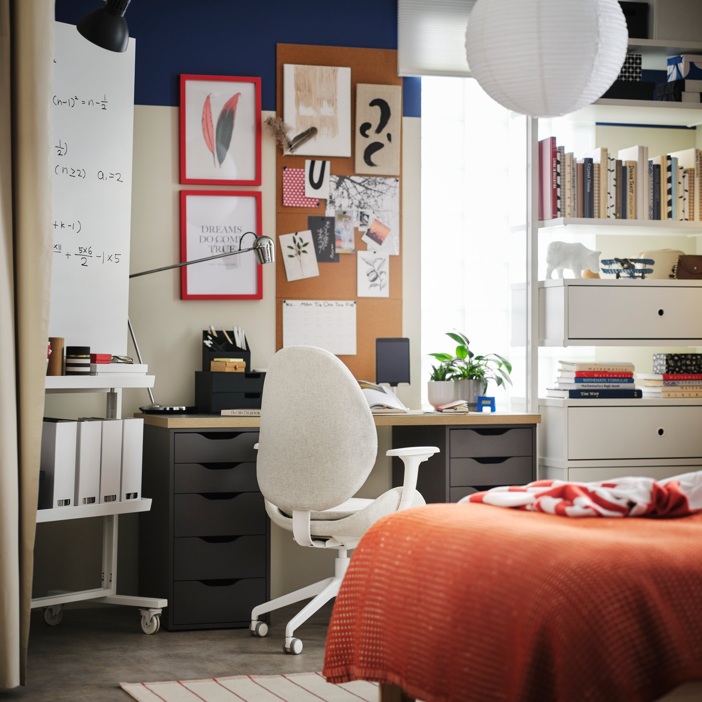 A beige white HATTEFJÄLL office chair with armrests in a bedroom in front of a FJÄDERHARV desk and beside a whiteboard.