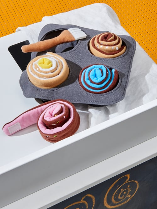 イエローのパンチングカウンターの上の布製おもちゃのDUKTIG/ドゥクティグ ロールパンと料理用ハケ、グレーの布製のベーキングトレイのクローズアップ