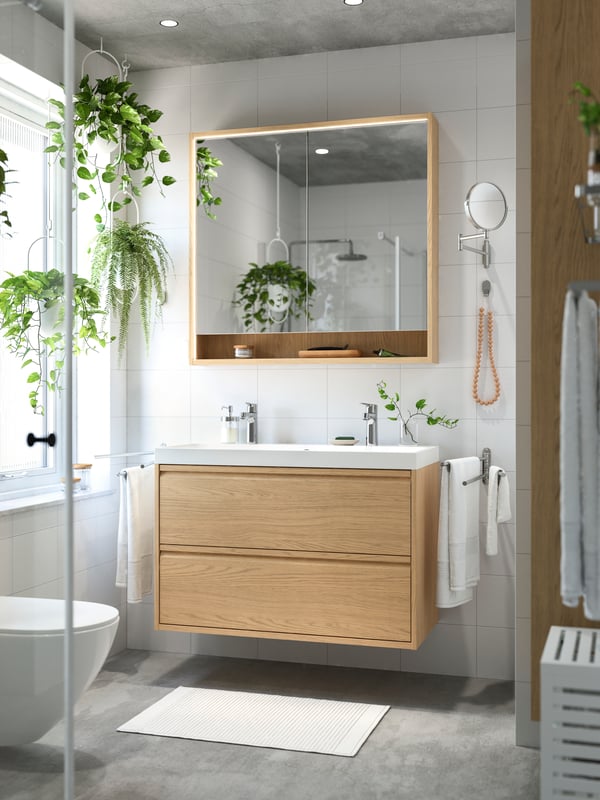 An oak effect ÄNGSJÖN high cabinet with door in the bathroom