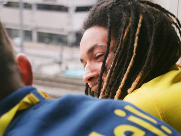 Two IKEA co-workers, one with dreadlocks, leaning forward and chatting.