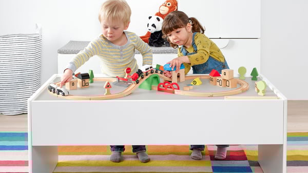 Kaksi lasta leikkii DUNDRA-aktiviteettipöydän ääressä LILLABO-sarjan junaradalla.