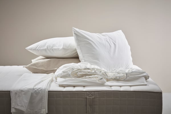 Твёрдый/тёмно-бежевый пружинный матрас HAUGESUND в спальне.