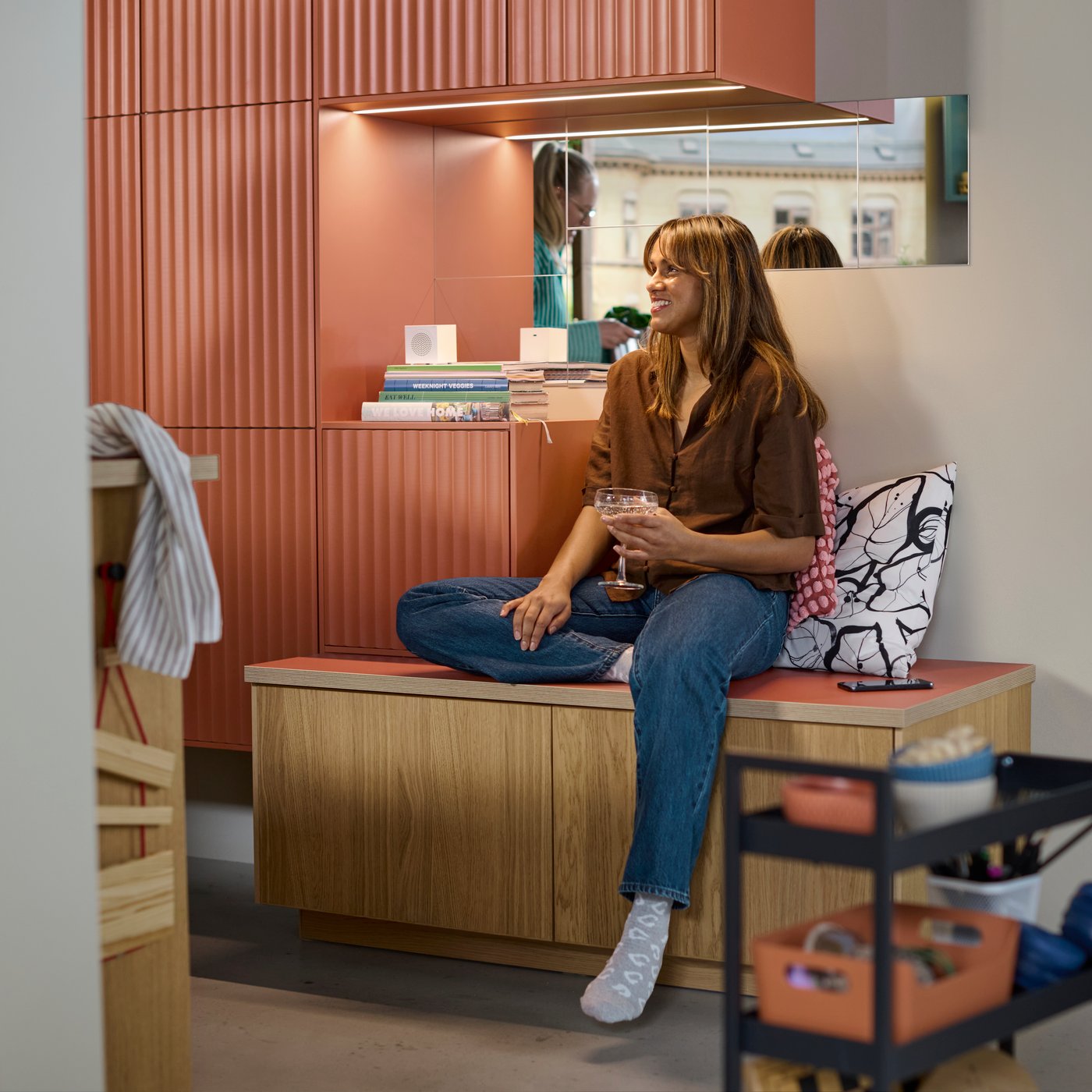 Een persoon rust op een zitplek gemaakt van METOD bovenkasten met TERRSJÖ accentdeuren en SINARP fronten.