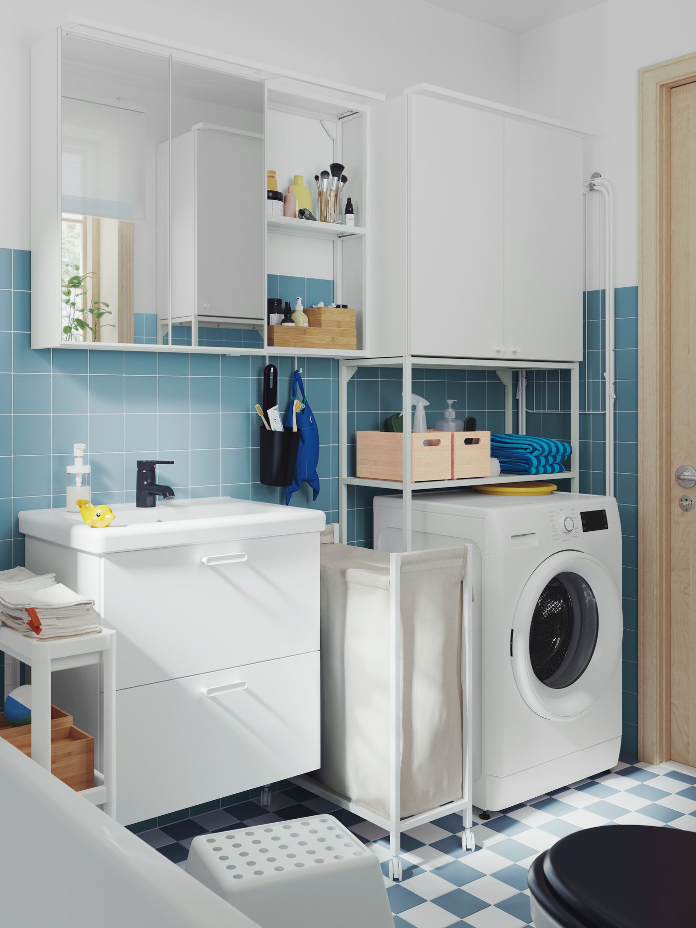 Malá, modře vykachlíčkovaná koupelna s bílou umyvadlovou skříňkou ENHET, zrcadlovou skříňkou, vysokou skříní a bílým vozíkem VESKEN.