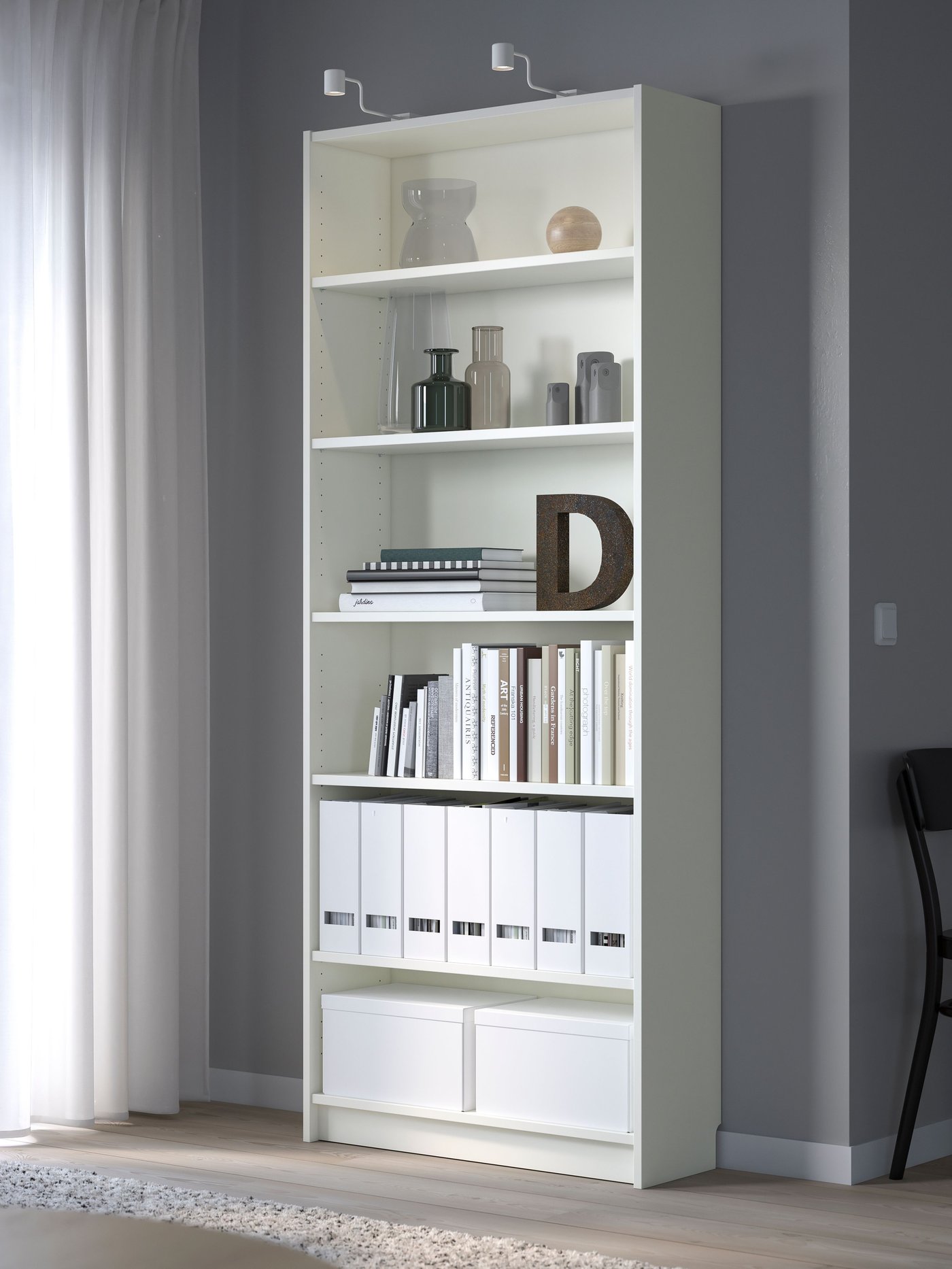 Un estante BILLY blanco con libros y cajas organizadas en sus repisas