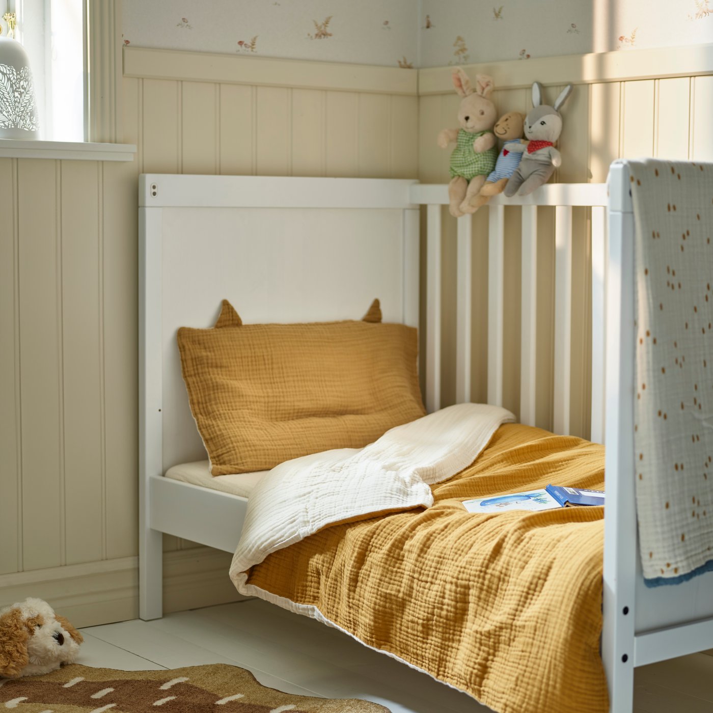 A dark yellow/beige GULDVÄVARE 3-piece bedlinen set for cot