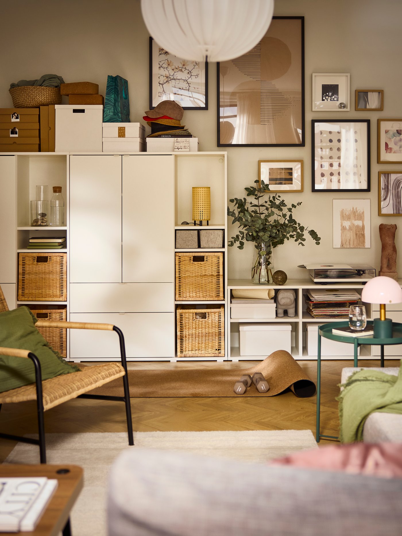 Stěna v obývacím pokoji, kterou zčásti zakrývá úložná sestava VIHALS a zčásti různorodá sbírka zarámovaných obrazů.