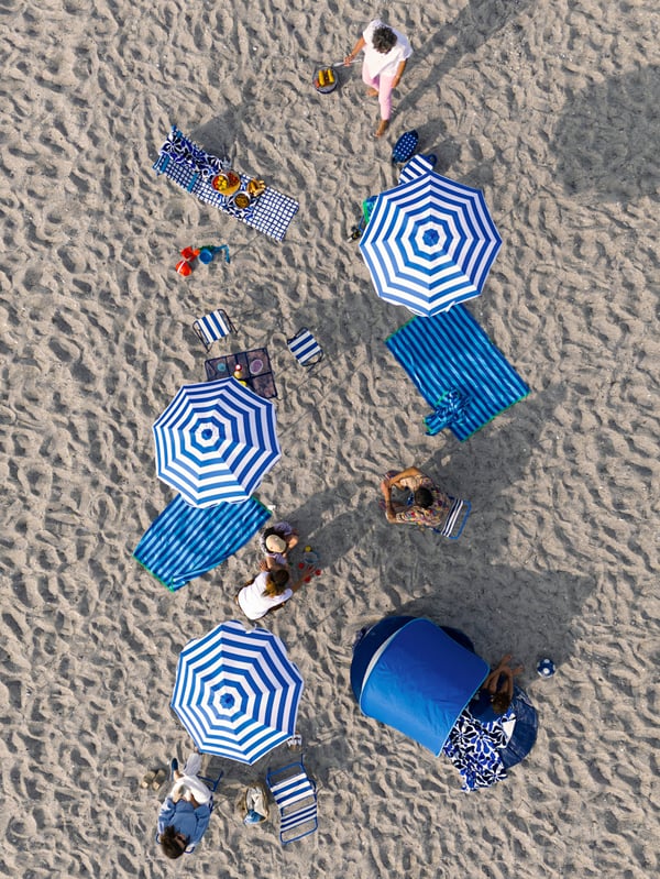 A blue STRANDÖN pop-up sun/wind shelter outside