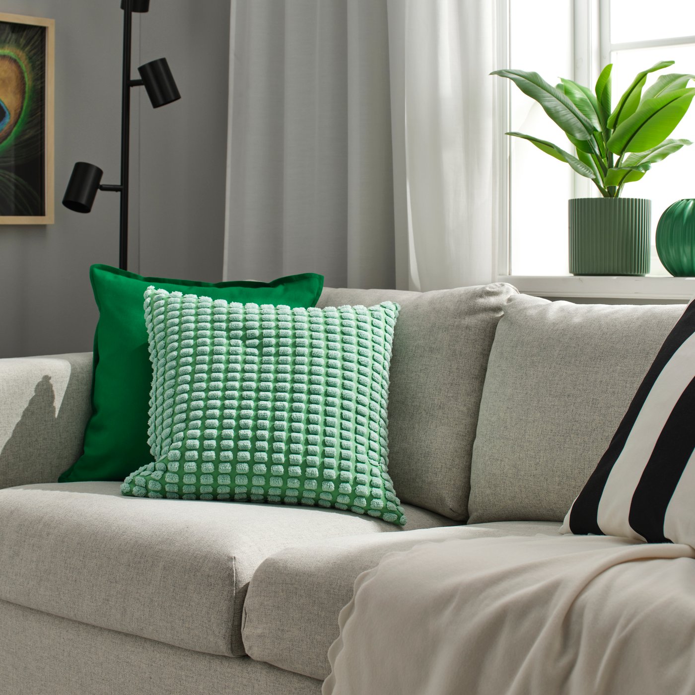 A light green SVARTPOPPEL cushion cover in the living room