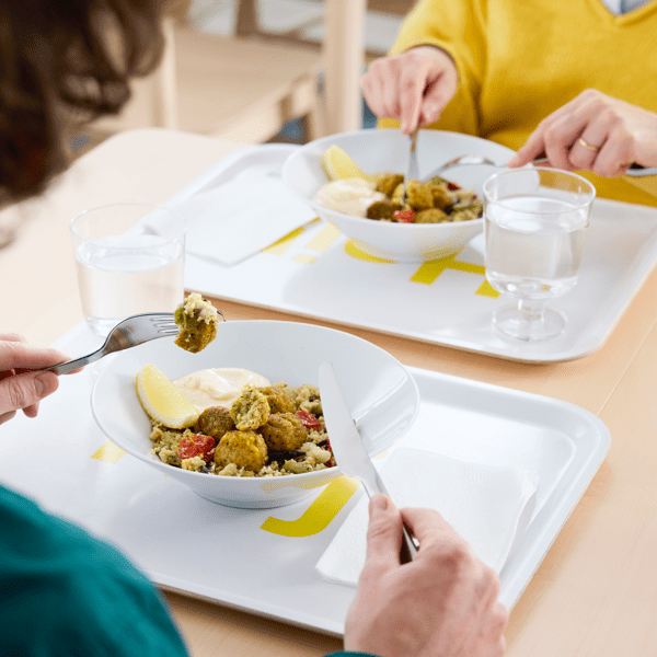 Två personer äter falafelmenyn i en IKEA restaurang