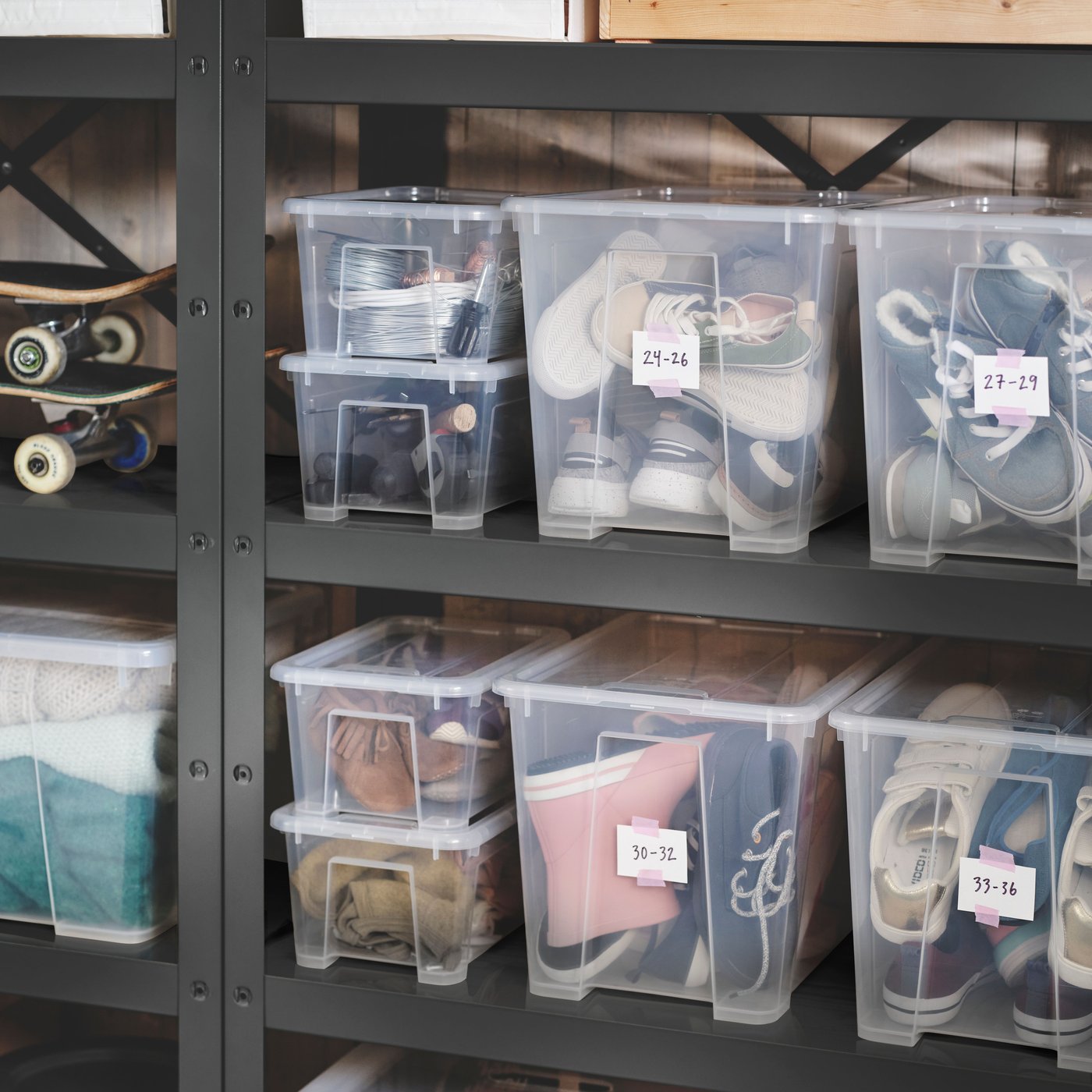 Two black BROR shelving units placed against a wall, holding different-sized SAMLA boxes with lid filled with shoes.