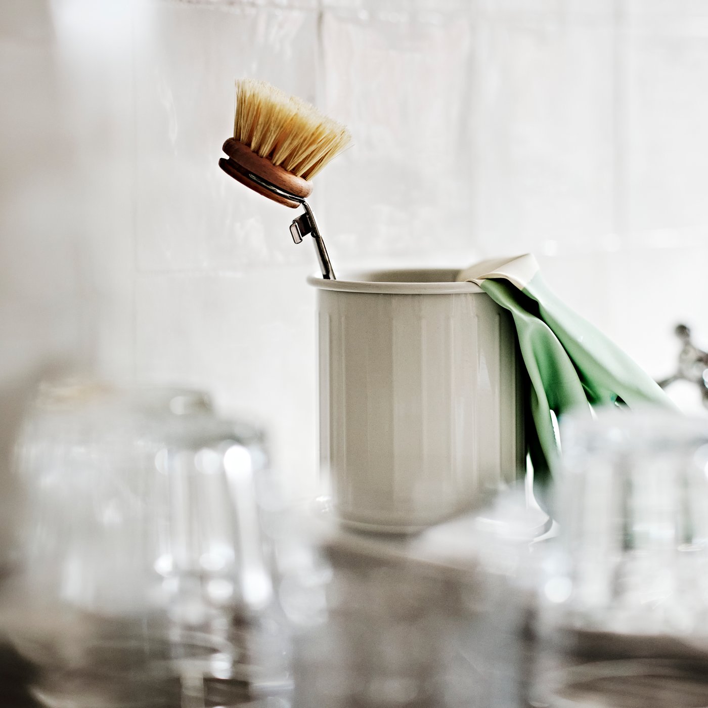 A VÄLVÅRDAD dish-washing brush and RINNIG cleaning gloves in a beige/galvanised VÄLVÅRDAD cutlery stand.