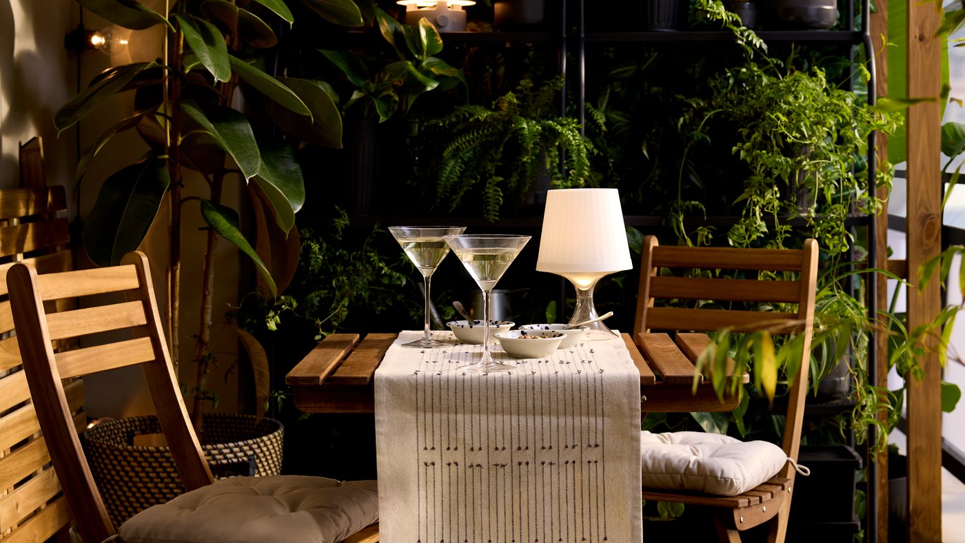 Een plastic LAMPAN LED lamp op tafel op een balkon
