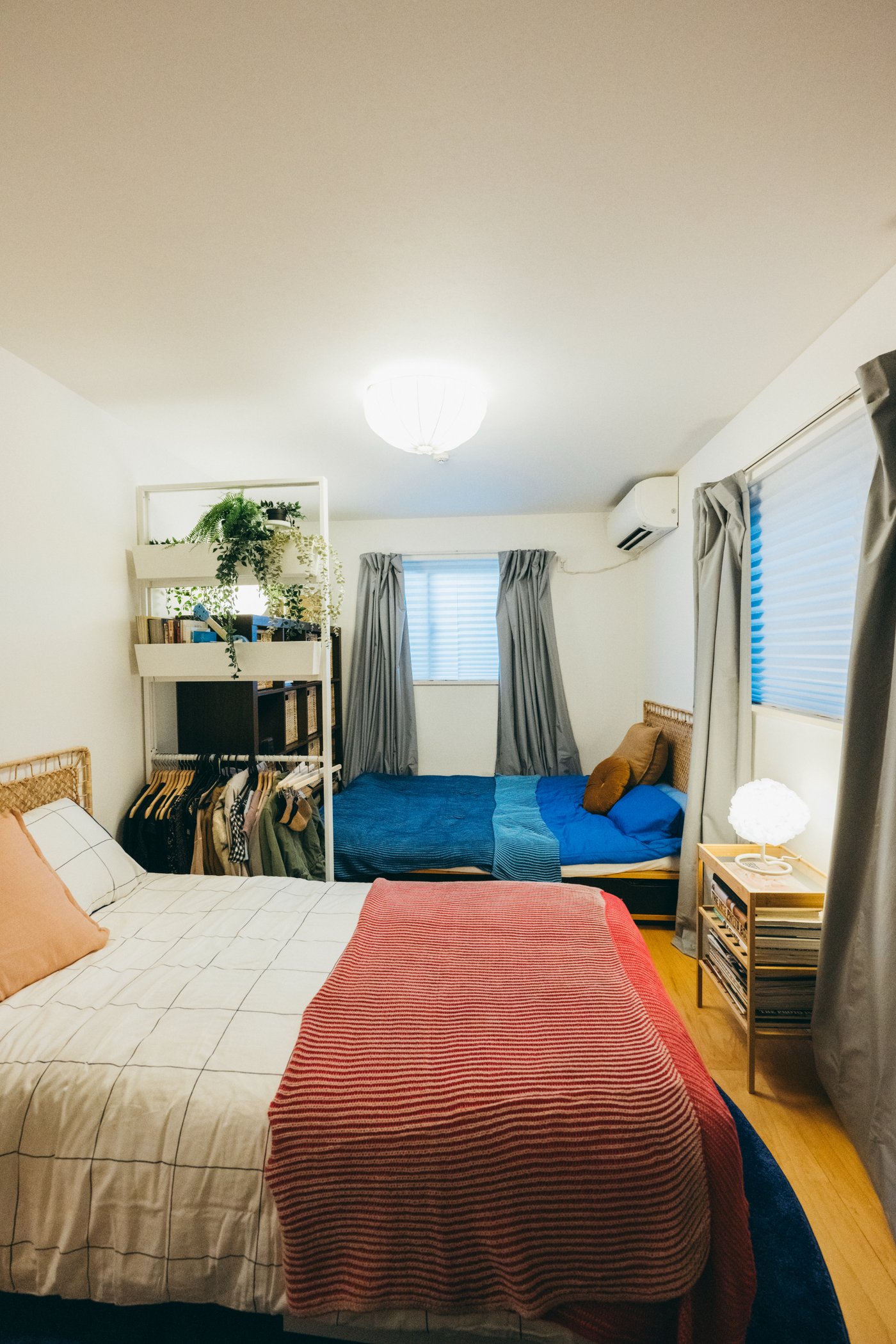 2つのベッドが互い違いに置かれ、間に収納ラックが置かれている。