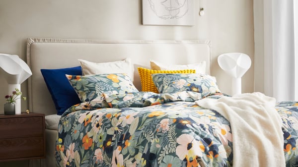 A flower doodle PJÄTTERYD picture in the bedroom with a bed in floral bedding.