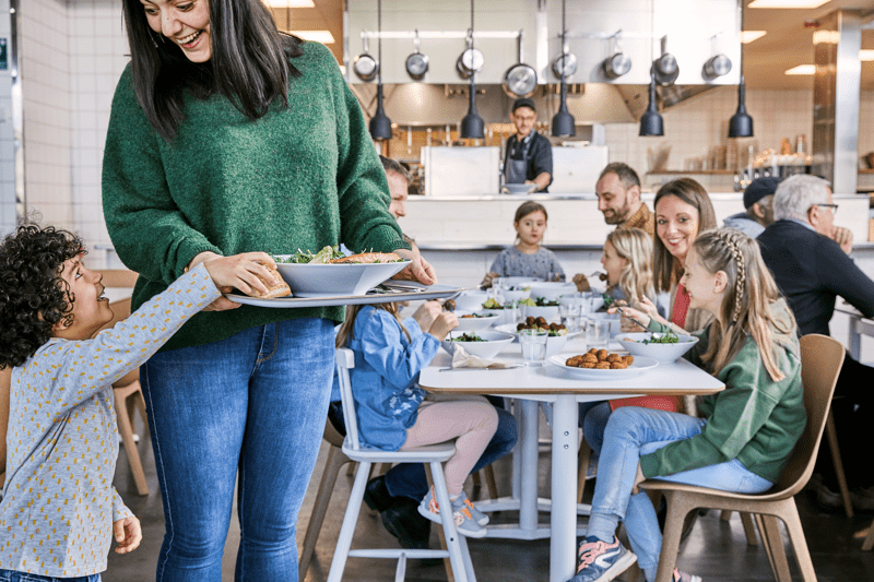 Delle persone in piedi e sedute al Ristorante svedese. 