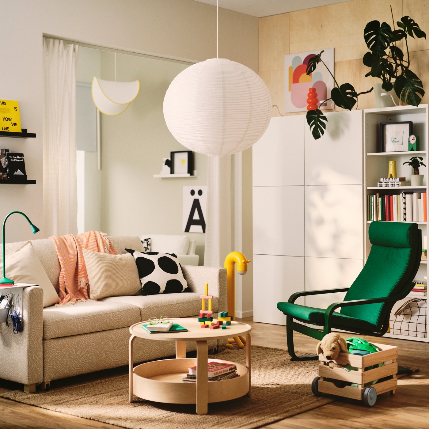 A living room features a light beige/white SALTSJÖBADEN 2-seat sofa-bed made from Vittangi. Decorative cushions and a table.