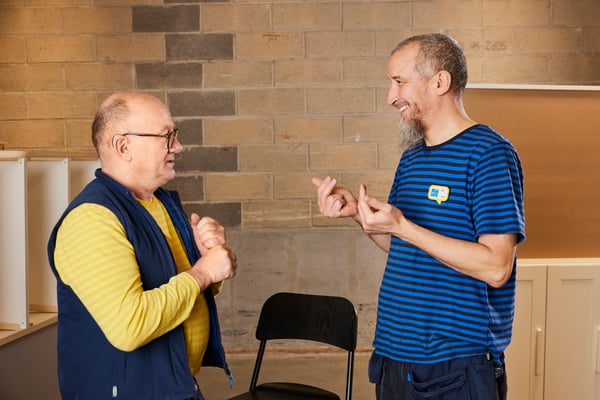 Two IKEA co-workers communicating through sign language.