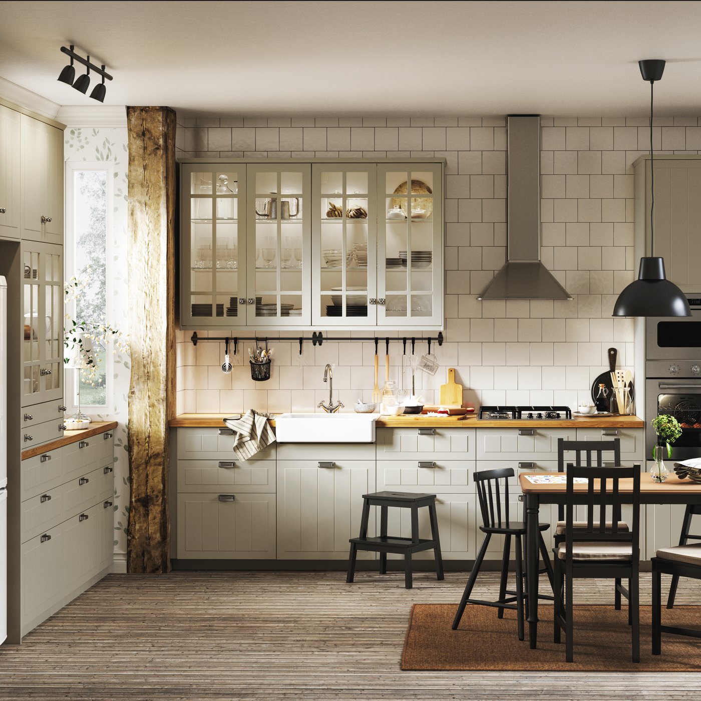 A traditional-style kitchen with beige cabinets, white tiles, wooden floors, floral wallpaper and a dark dining set.