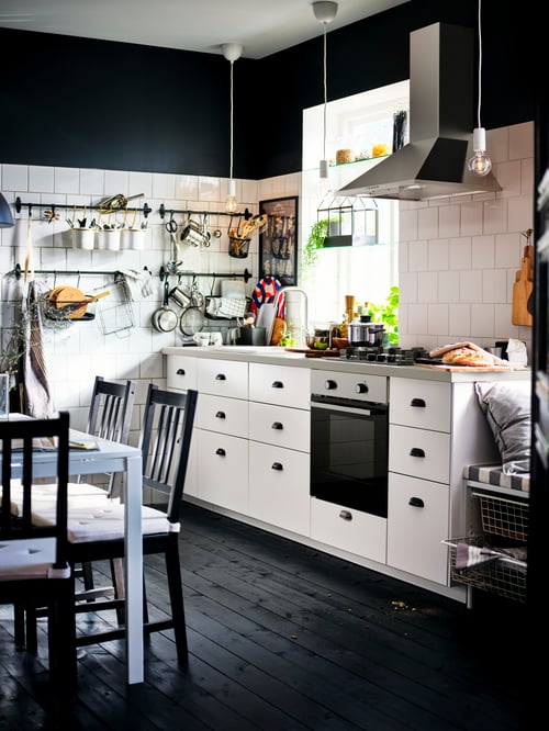 Kitchen with base cabinets with three drawers, a decoration greenhouse, an oven, an extractor hood, chairs, and a gas hob.
