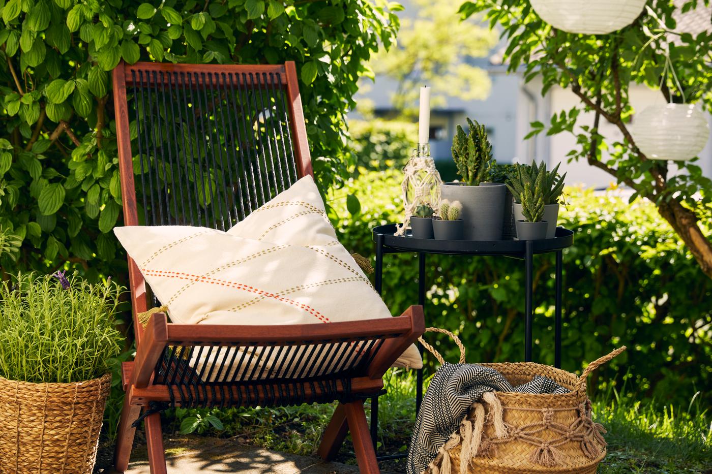 Liegestuhl aus Holz und Beistelltisch mit Pflanzen
