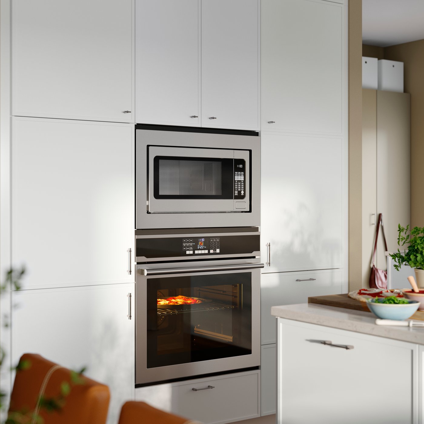 A kitchen featuring a stainless steel VASKARBO wall oven and an ÄSKEBO microwave placed above built into high cabinets.