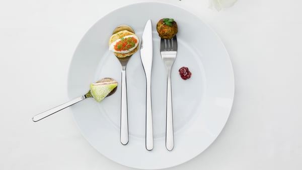 Un ensemble de FÖRNUFT ustensiles sur une assiette blanche. Chaque ustensile contient un plat différent, comme un gâteau et du caviar.