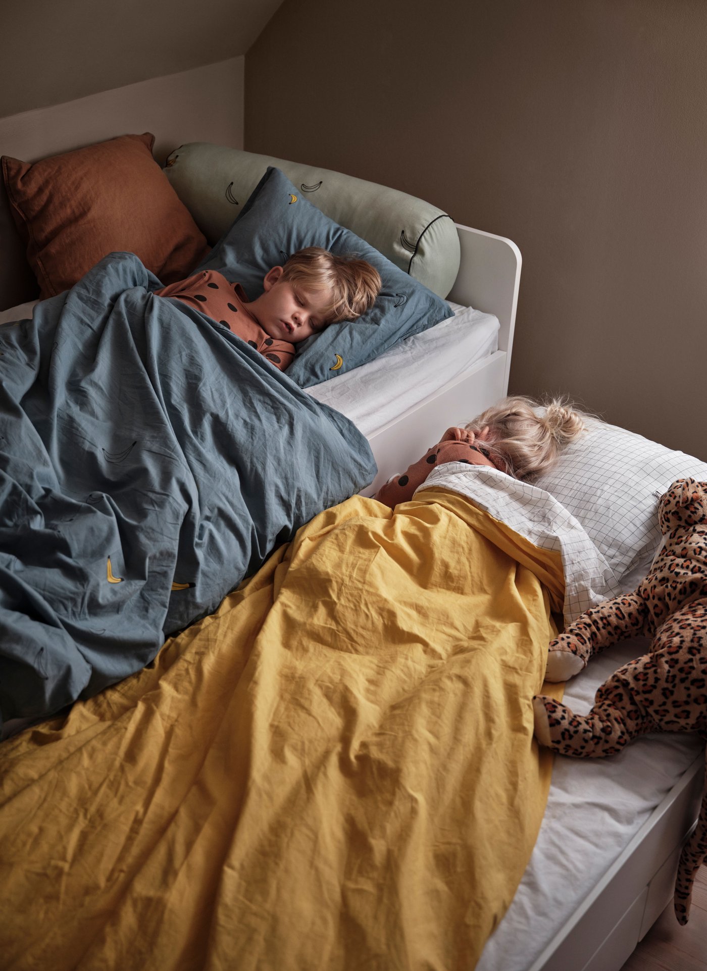 Unha estrutura de cama SLÄKT branca con cama inferior e almacenaxe no cuarto dos nenos