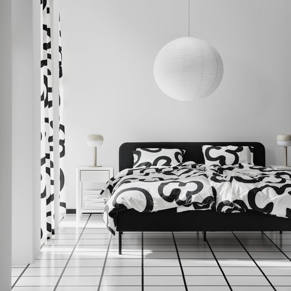 A Vissle dark grey SLATTUM upholstered bed frame in the bedroom