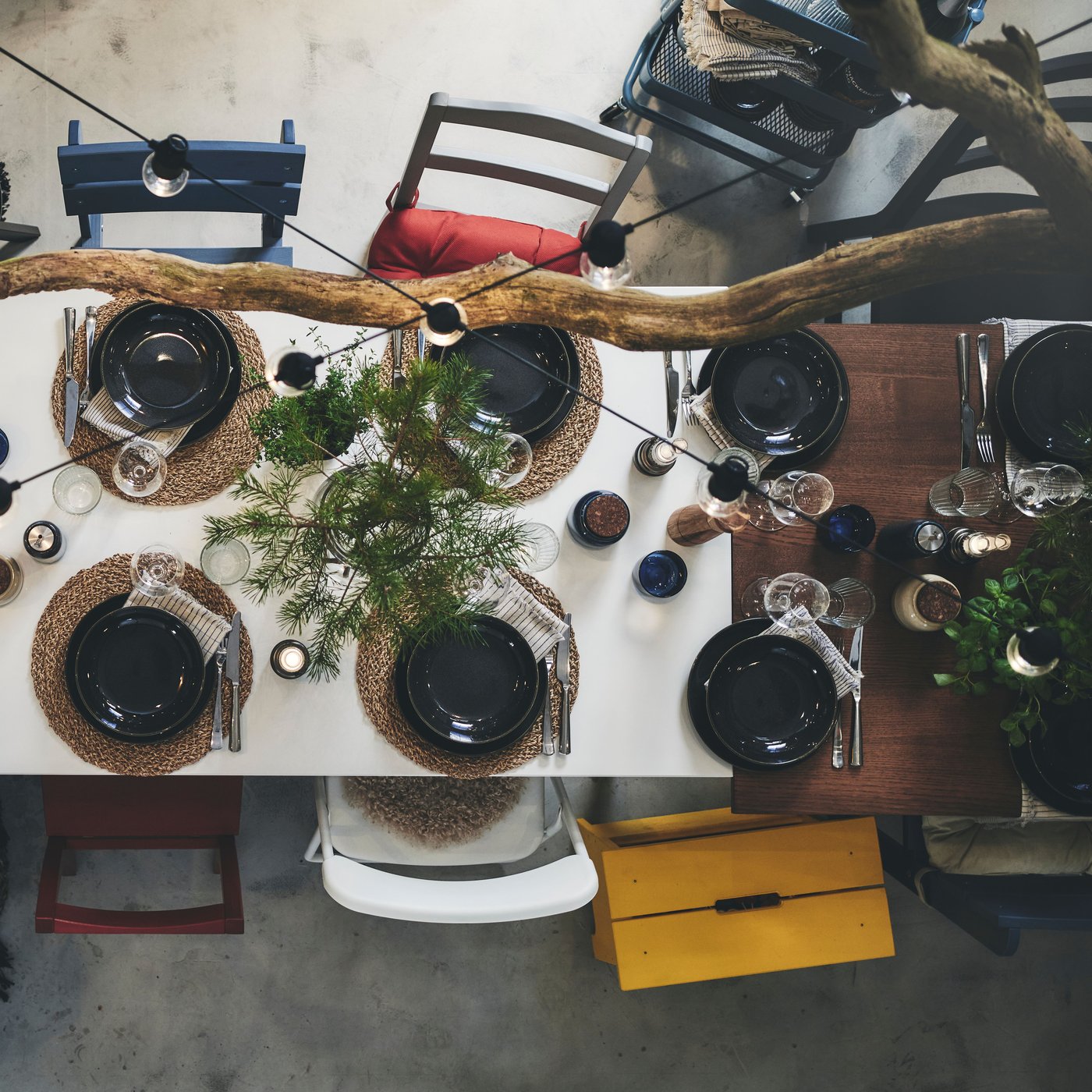 Vue en plongée sur une table de Noël décorée de branchettes et dressée avec un service de Noël dans des couleurs naturelles