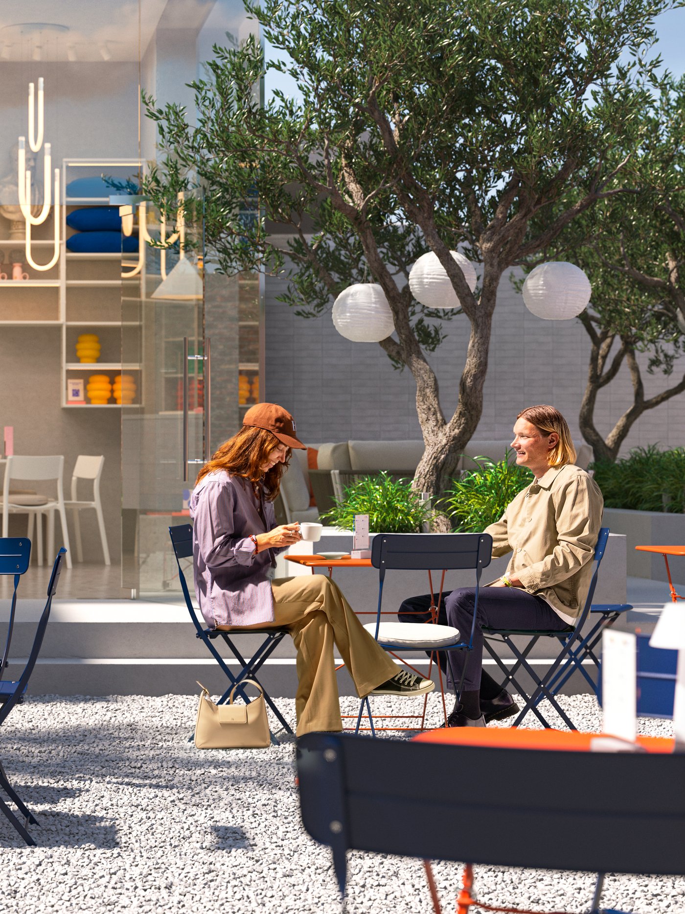 A café with an indoor and a sunny outdoor space with trees, different lamps and customers sitting at the SUNDSÖ bistro sets.