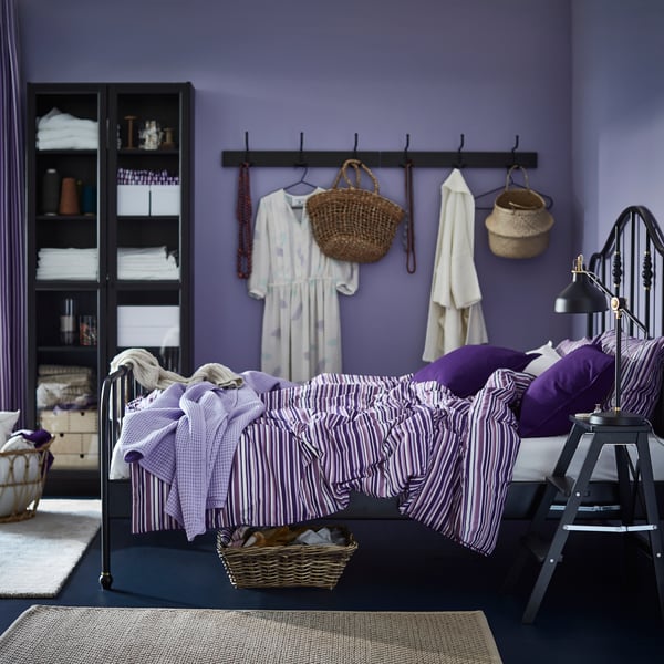 A bedroom with hanging rack on the side