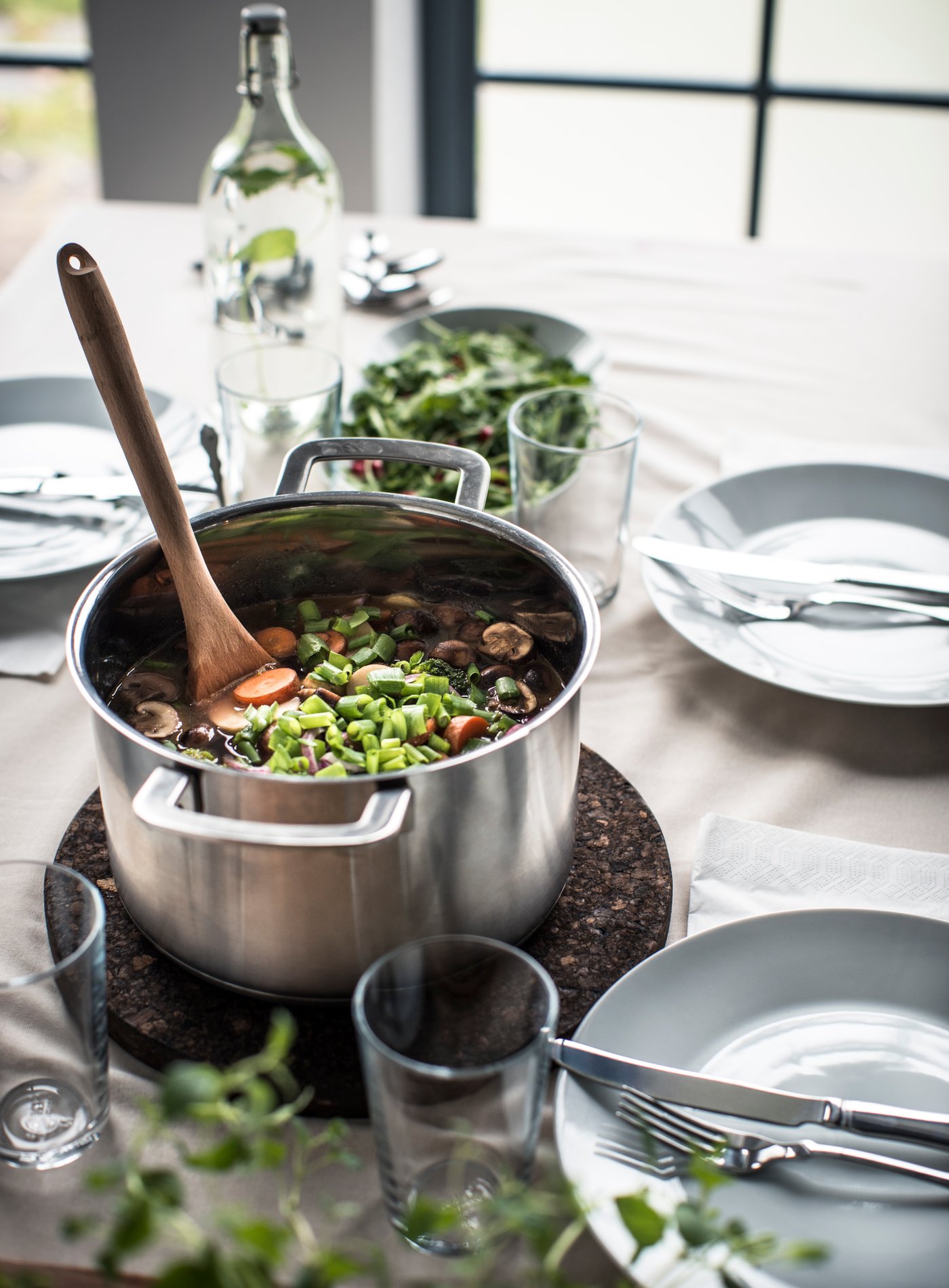 IKEA 365+ stainless steel pot with food and wooden ladle.