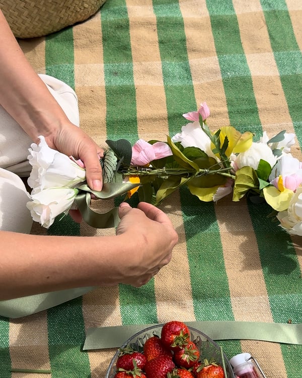 Midsommarkransen får ett sidenband för att knytas runt huvudet.