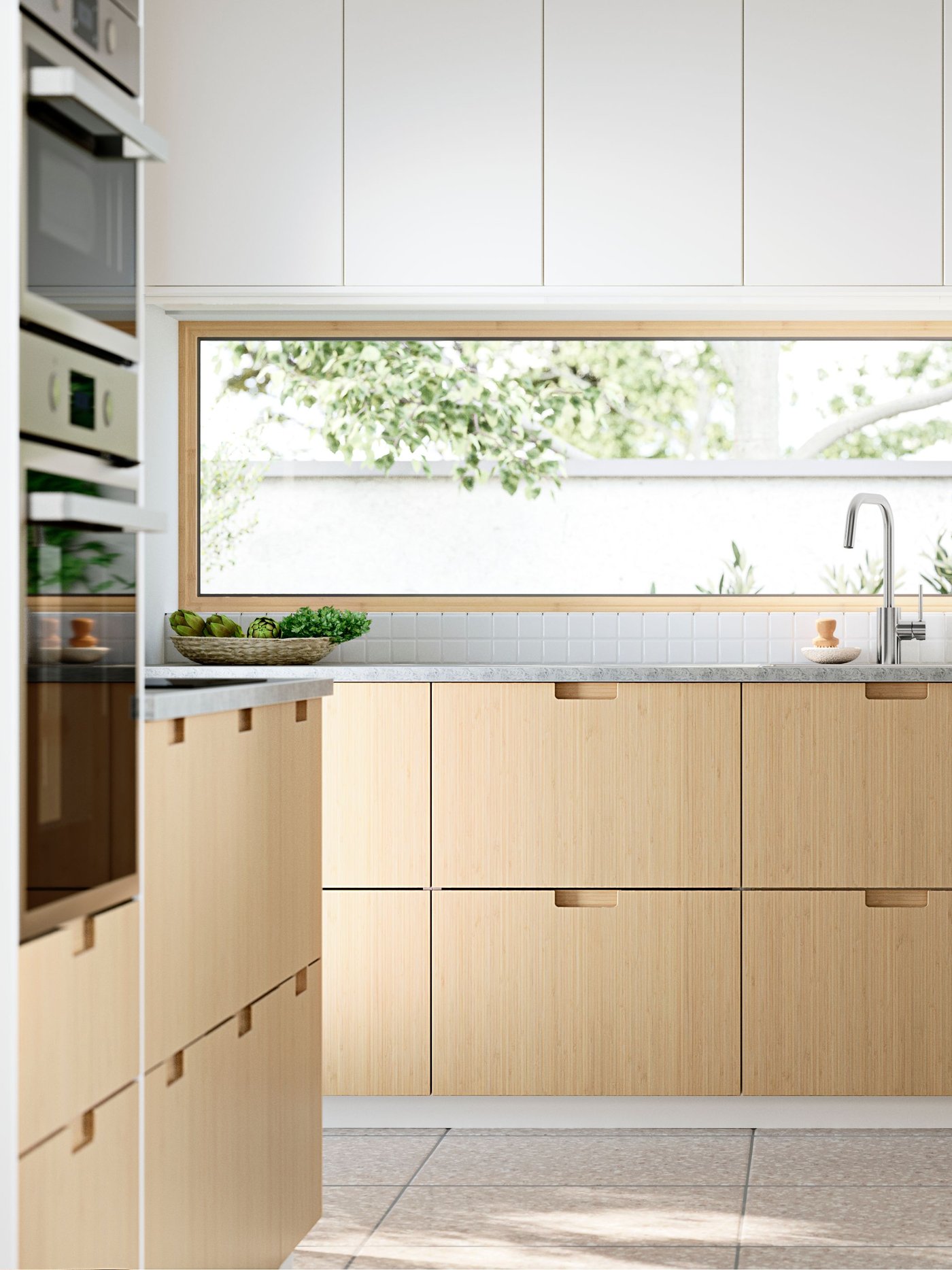 A sun-drenched kitchen with windows facing the garden. FRÖJERED kitchen fronts, in bamboo, are combined with fronts in white.