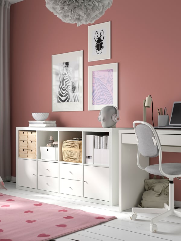 A pink BARNDRÖM rug and white KALLAX shelving unit with 4 inserts in children's room