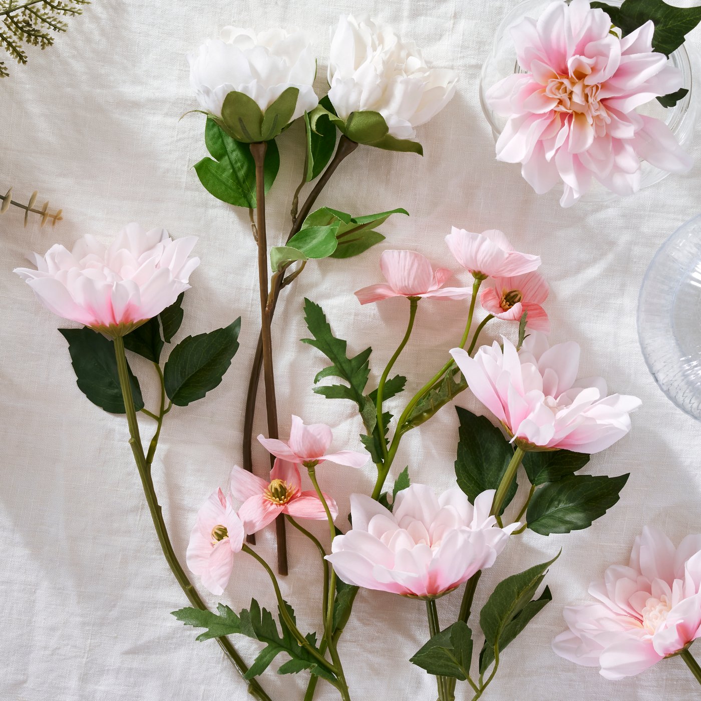 White peony SMYCKA artificial flowers and pink dahlia SMYCKA artificial flowers lie on a white surface.