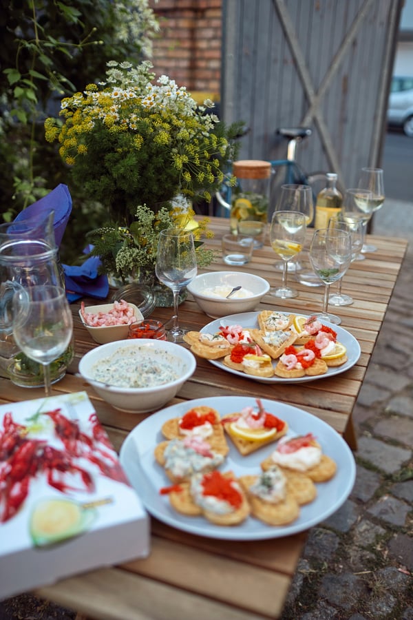 A table set with plates of waffles, crayfish and dip sauces.