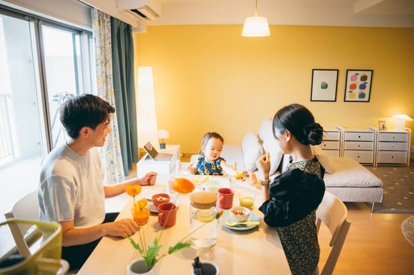 ダイニングテーブルで食事をとる相談者家族
