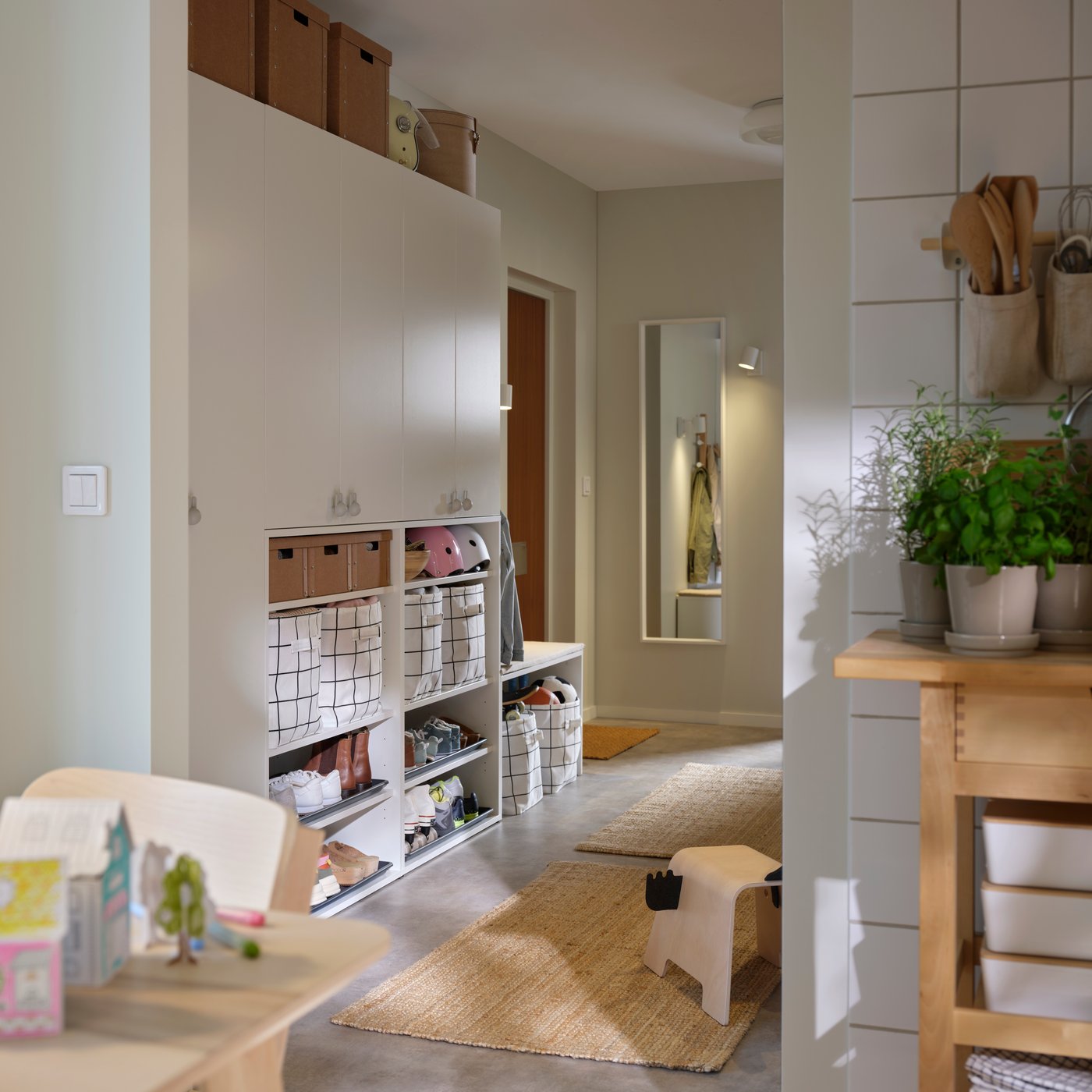 Entrée avec rangements et paniers près d’un mur où est fixé un miroir NISSEDAL, à côté d’une porte d’entrée.