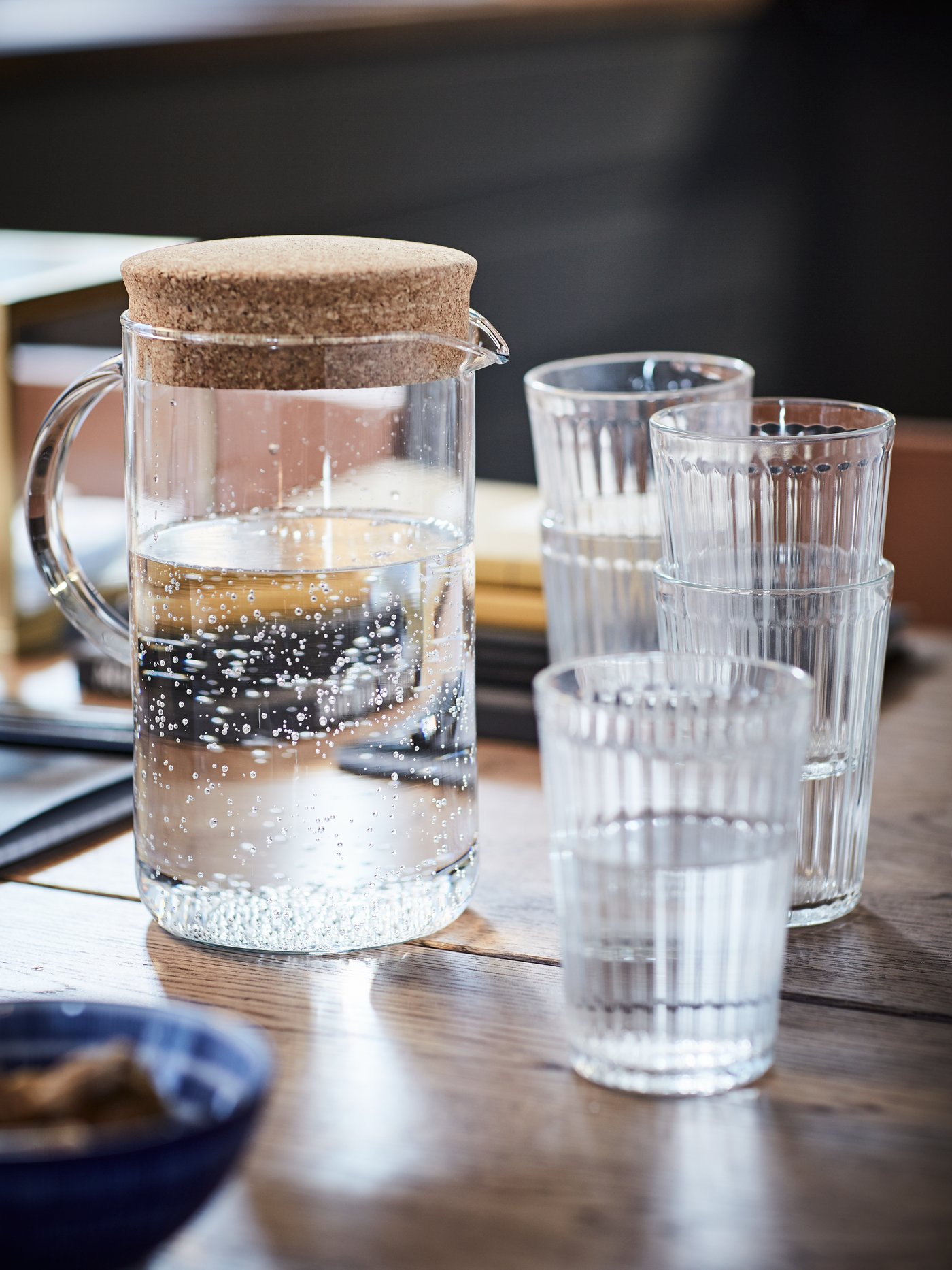 Una jarra y vasos VARDAGEN llenos de agua.